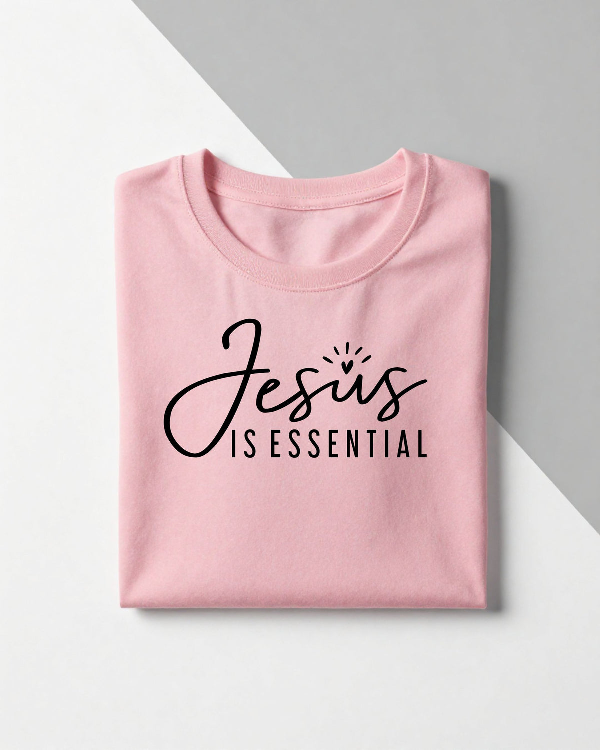 Jesus is Essential Christian graphic tee folded pink t-shirt