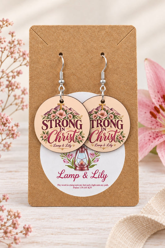 Strong in Christ round Lamp & Lily earrings on silver hooks displayed on a kraft earring card