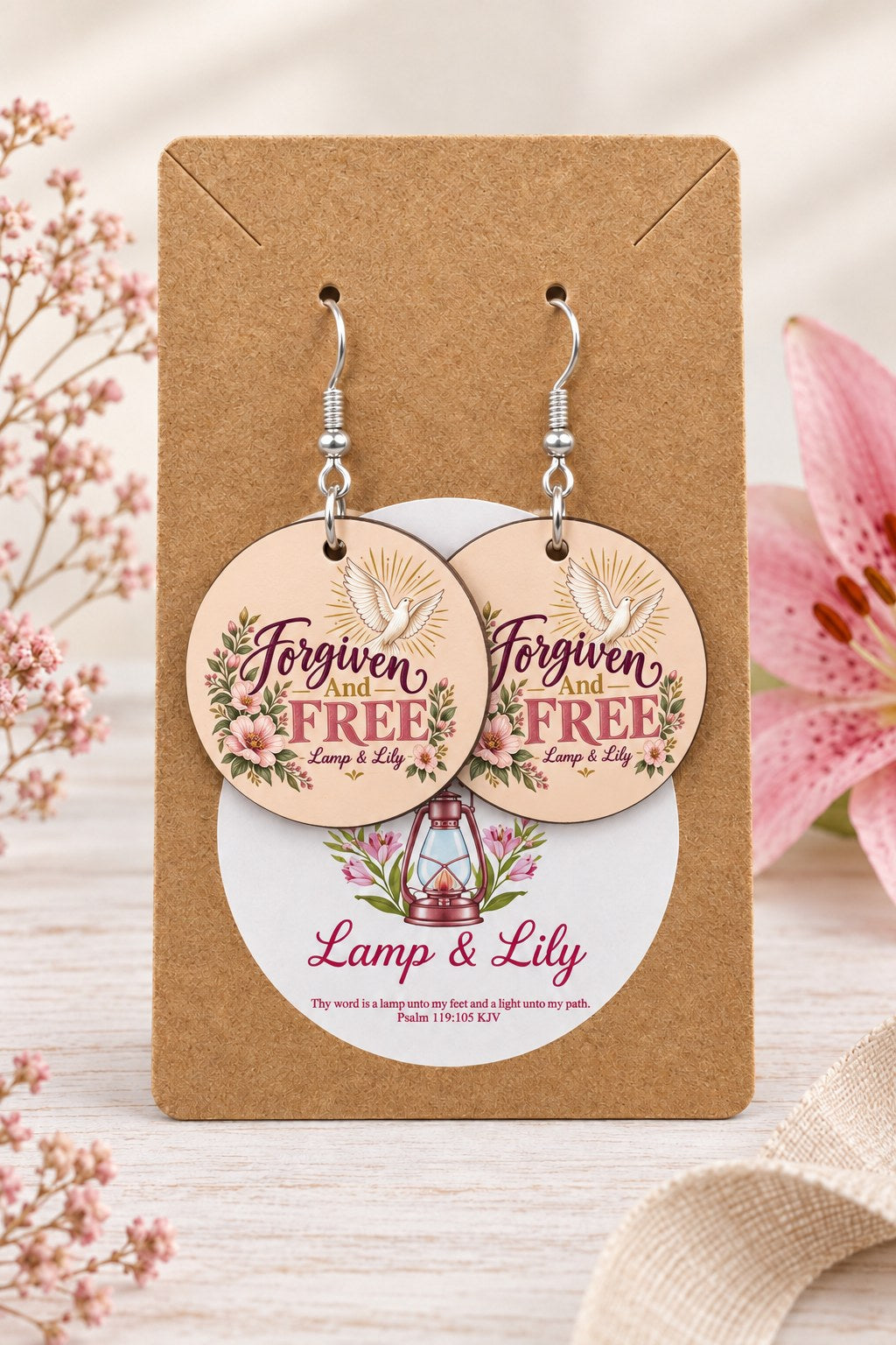 Forgiven and Free round Lamp & Lily earrings on silver hooks displayed on a kraft earring card
